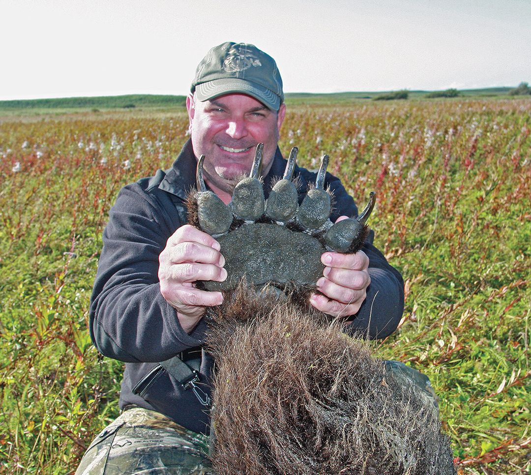 Jeff holds up the massive paw of his brown bear.